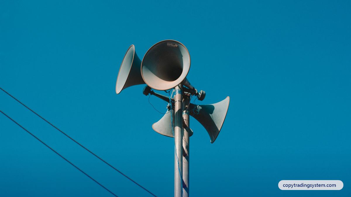 Copy trading referral program: loudspeakers on a pole against a blue sky
